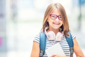 little girl with braces and headphones